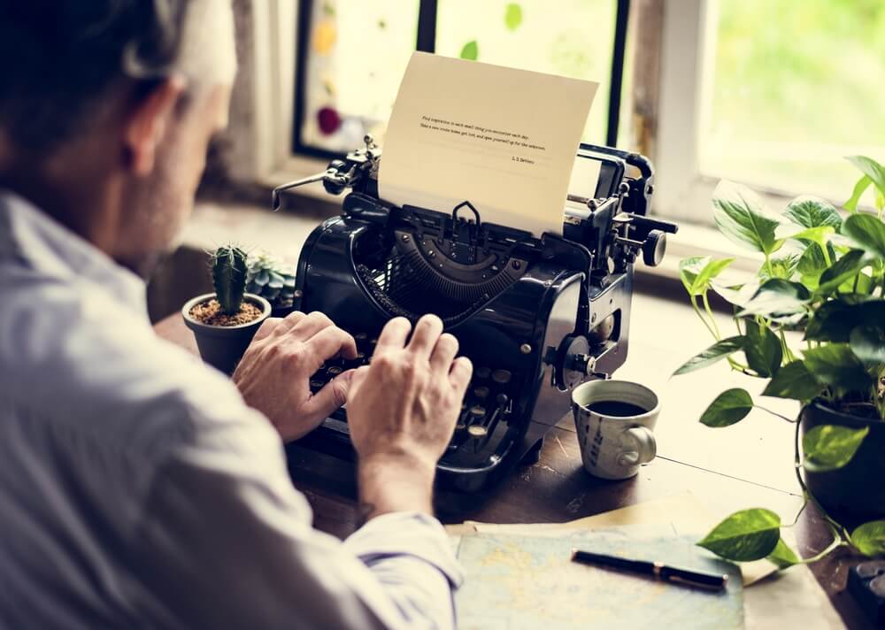 man typing on retro typewriter