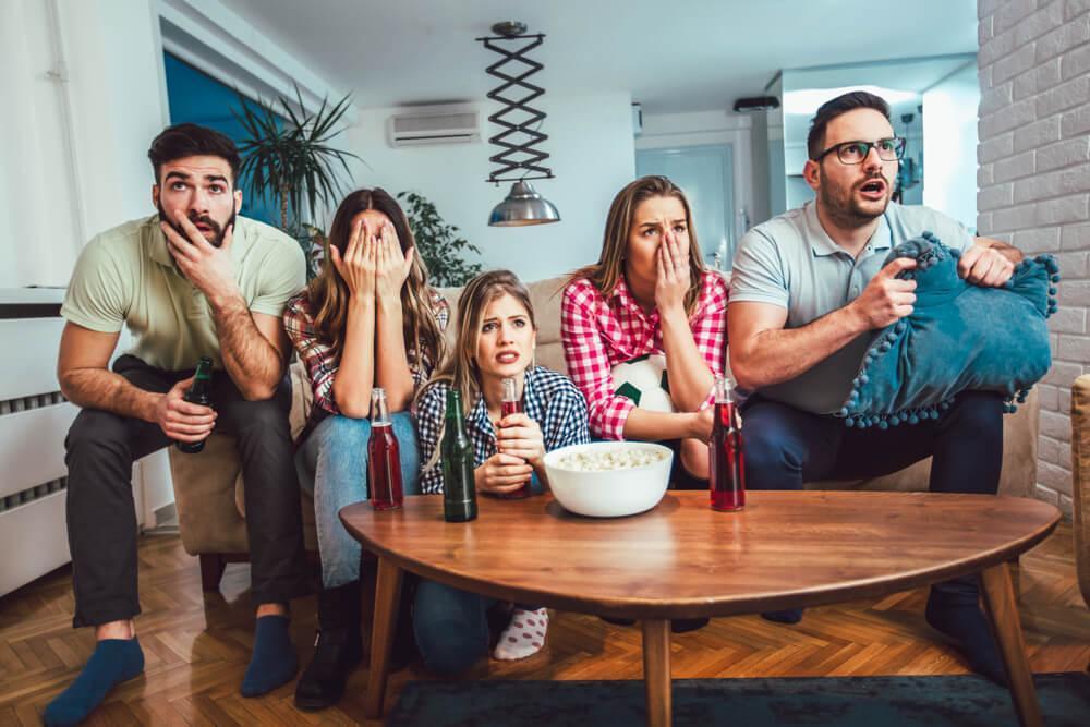 A group of five friends watching TV