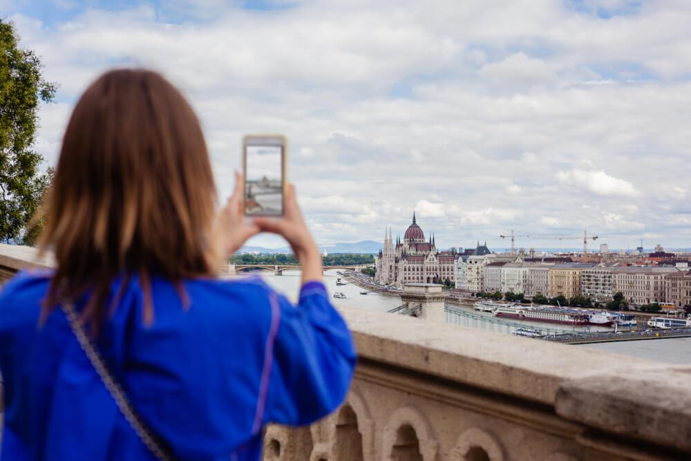 Woman taking photo of landmark in city