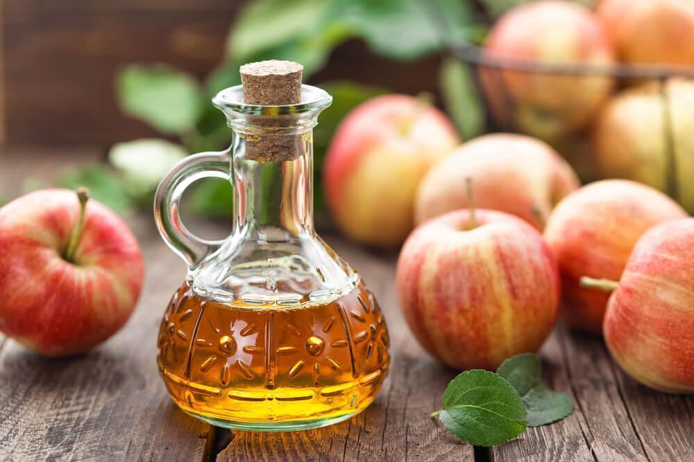 Apple cider vinegar next to apples