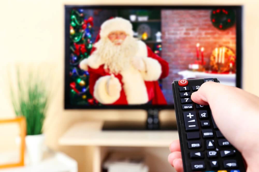 Santa on TV and hand holding remote
