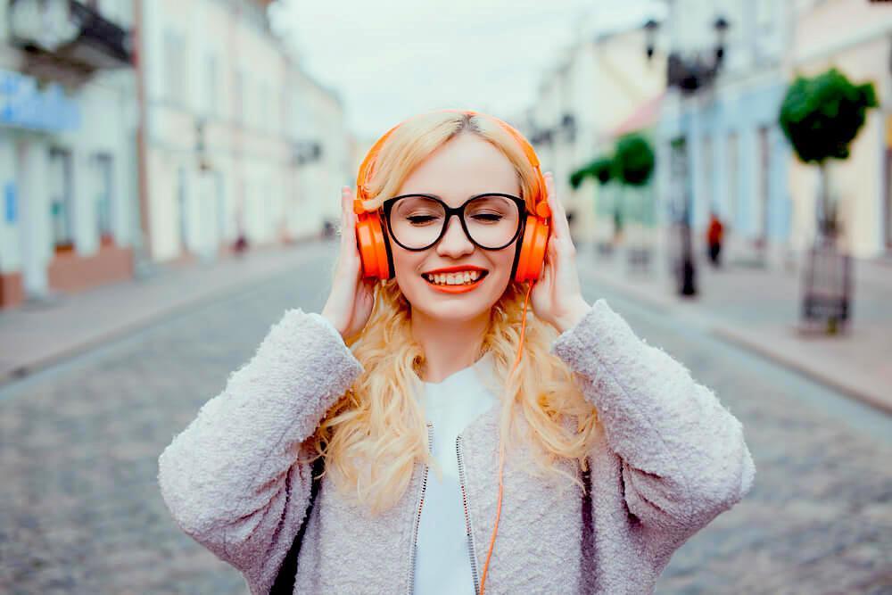 Woman listening with orange headphones