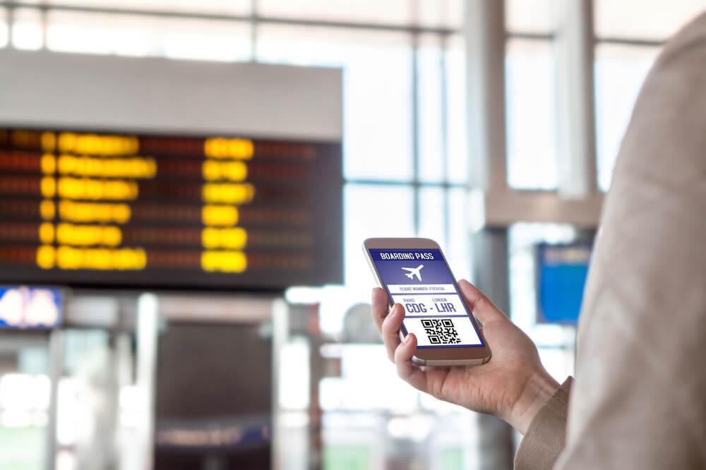 Phone with boarding pass being held up in airport