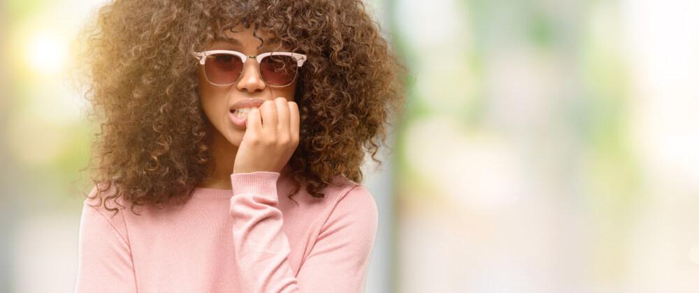 Woman on street biting nails