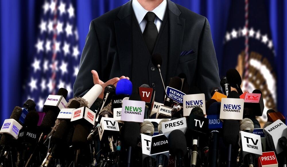 Man with microphones from media held up to him