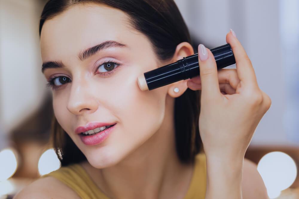 Woman applying concealer