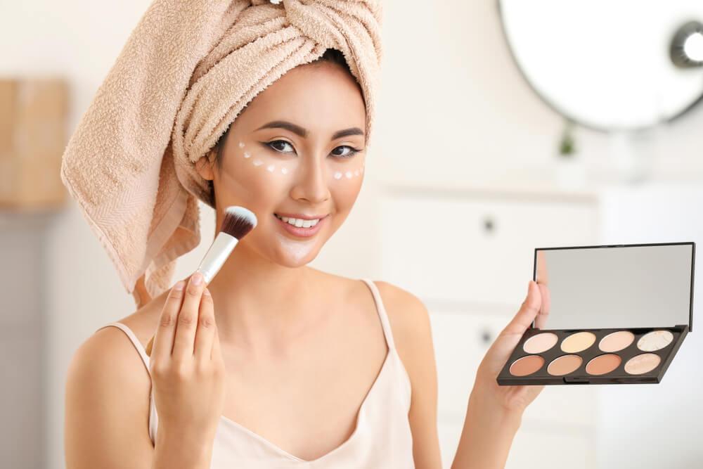 Woman applying highlighter to face