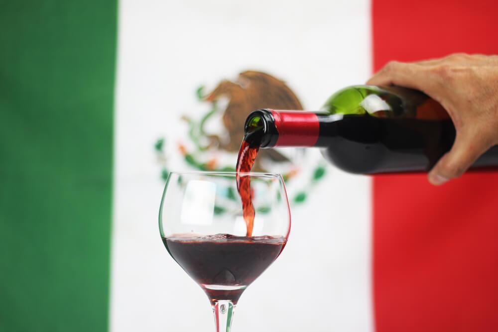 Pouring wine in front of Mexican flag