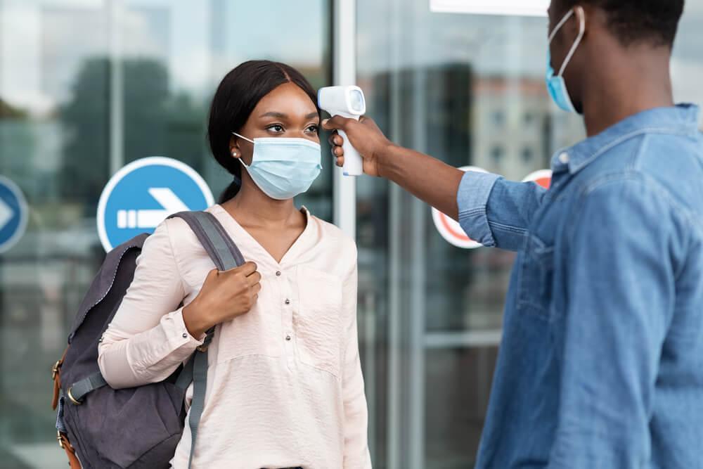 Airport staff checking passenger temperature