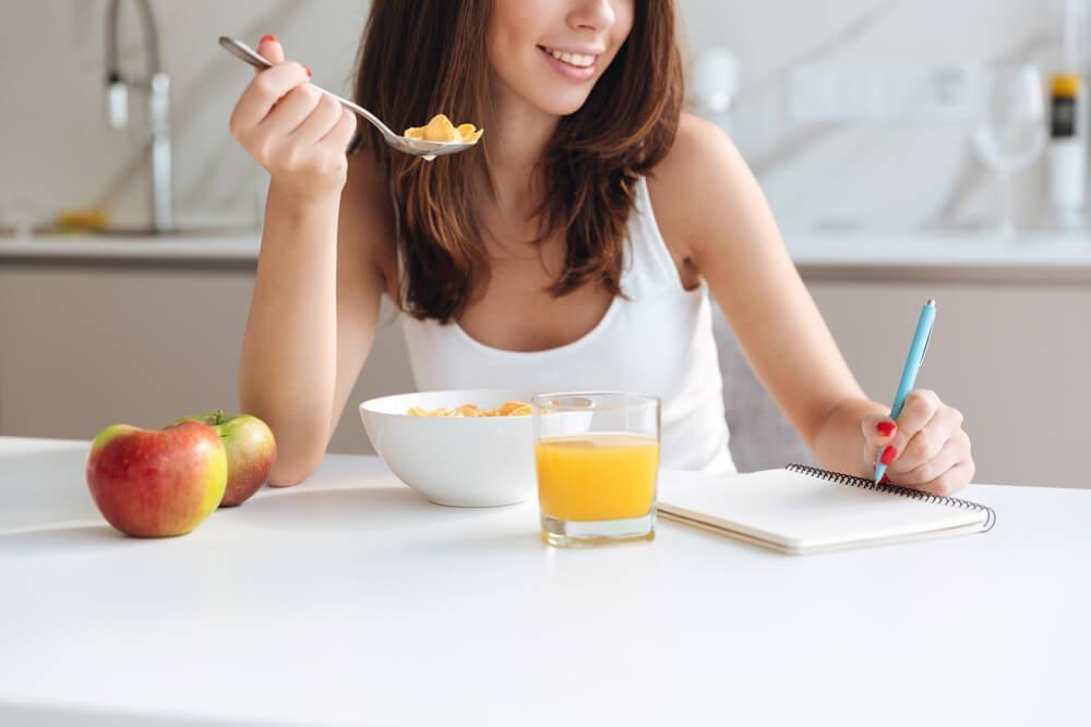 Woman writing while eating